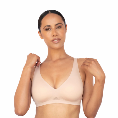 Woman wearing a beige bra on a white background